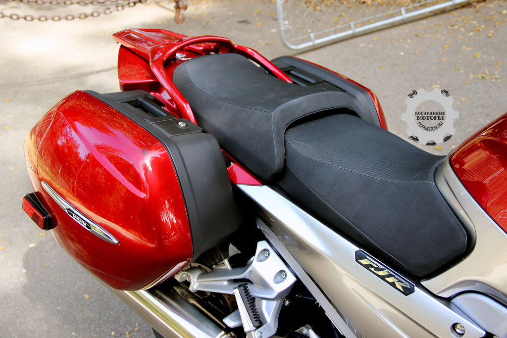На мотоцикле множество сумок и регулируемое сиденье. На фото оно в своём низком положении.