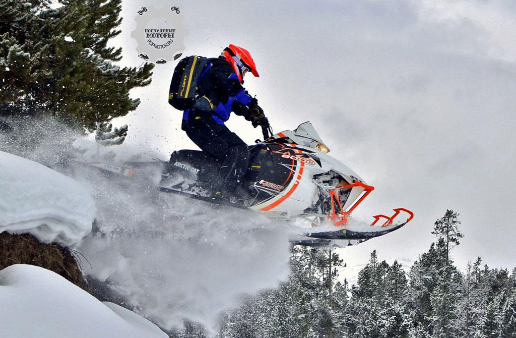 Съезжая с холма на мягкий снег, водитель-испытатель выжимает газ на новом M8000, и гусеница PowerClaw запускает снегоход в воздух.